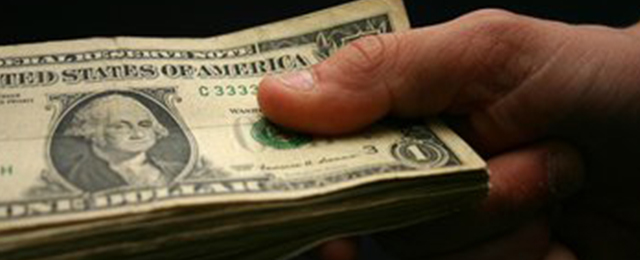 hand holding stack of dollar bills