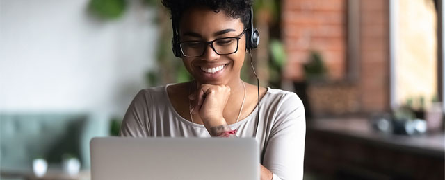 Smiling woman looks at computer screen