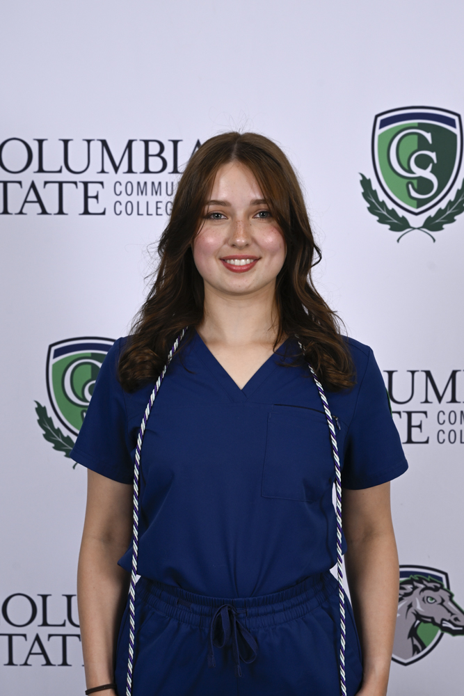A person stands in front of a white background.