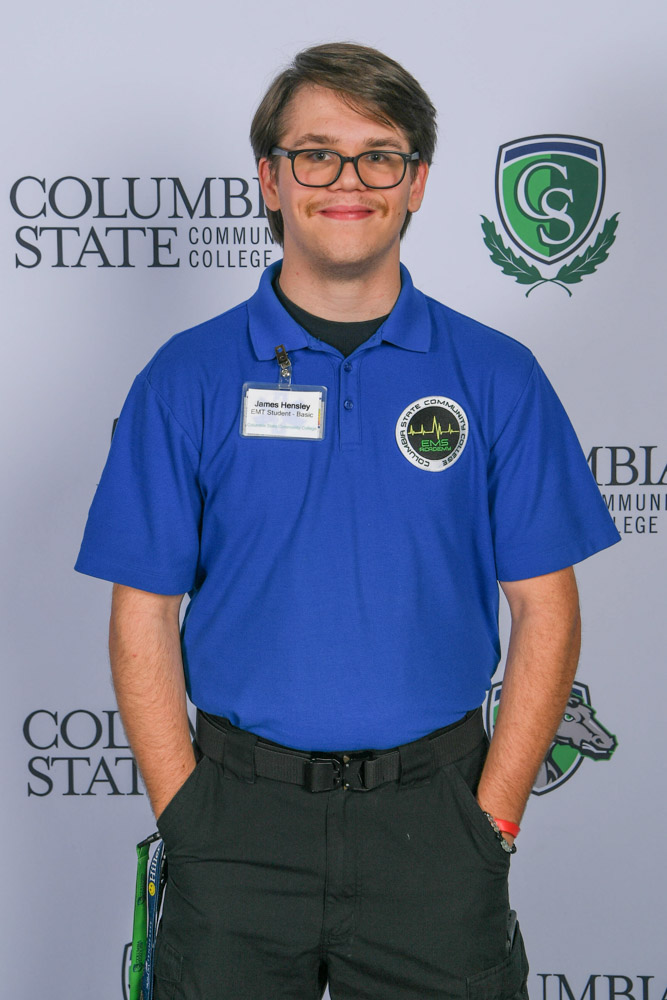 A man stands in front of a white background.
