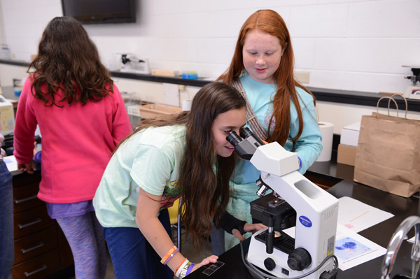 Kiara Simply and Taylor Makes look at microscope at 2016 STEM GiRLS